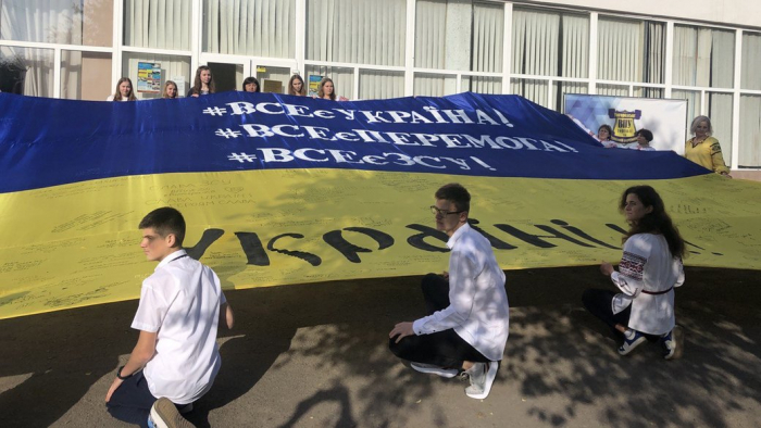 "Хочу, щоб стяг побачив мій брат, який зараз воює". В Ужгороді учні писали побажання воїнам ЗСУ на 12-метровому прапорі